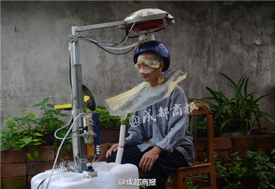 El padre de Chen Gongke utiliza la lavadora automática de cabello en Leshan, provincia de Sichuan, el 16 de septiembre de 2015. (Foto/Chengdu Business Daily)