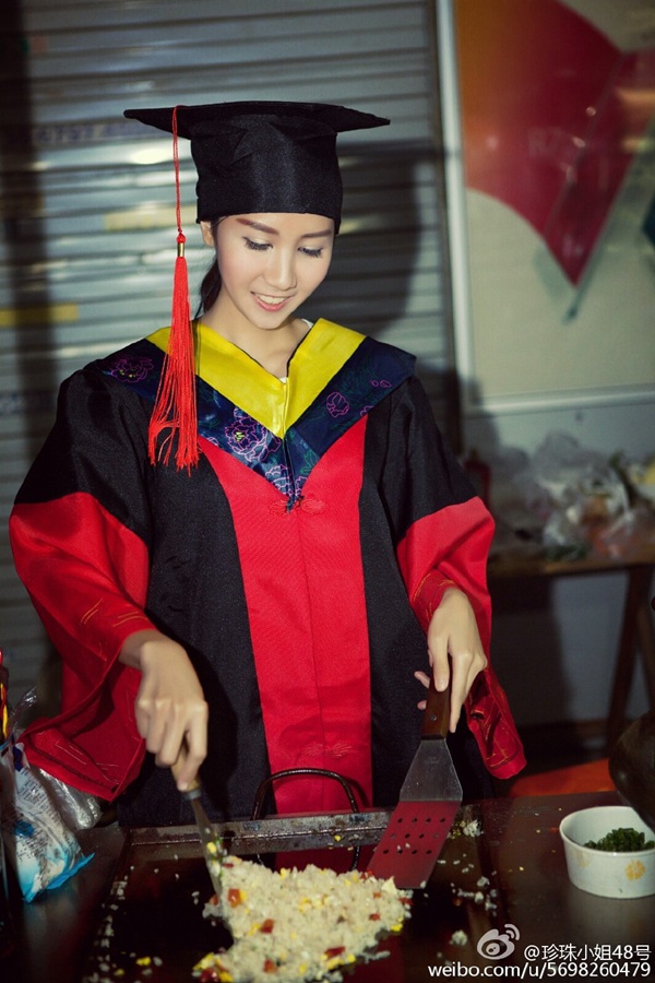 Foto de la joven con toga y birrete cocinando arroz frito. (Foto/Weibo)