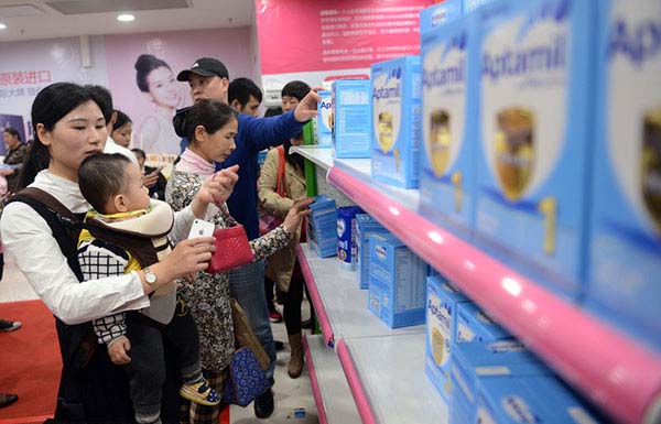 Una mamá china compra pa?ales con su bebé a cuestas en un supermercado de Guangzhou, provincia de Guangdong, el 23 de enero. 