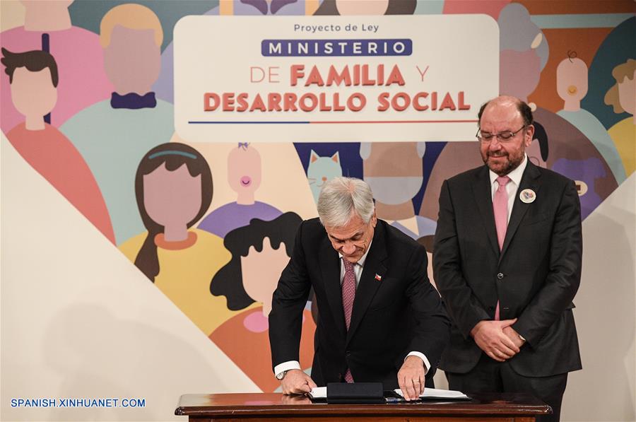 El presidente de Chile, Sebastián Pi?era (i), junto al ministro de Desarrollo Social de Chile, Alfredo Moreno (d), se dispone a firmar el proyecto de ley para la creación del Ministerio de Familia y Desarrollo Social, en el Palacio de La Moneda, en Santiago, capital de Chile, el 26 de julio de 2018. (Xinhua/Jorge Villegas)