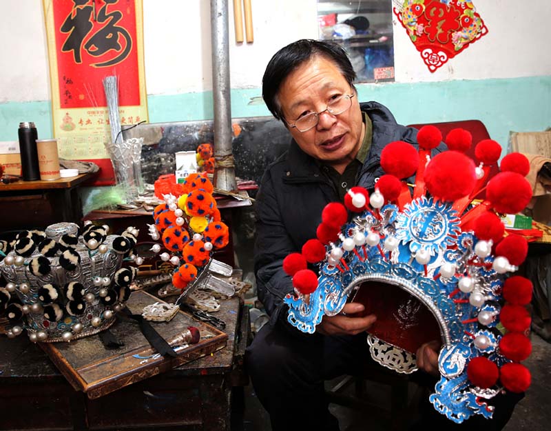 Han Xiaoli muestra un sombrero que él mismo realizó. [Foto: Huo Yan/ Chinadaily.com.cn]