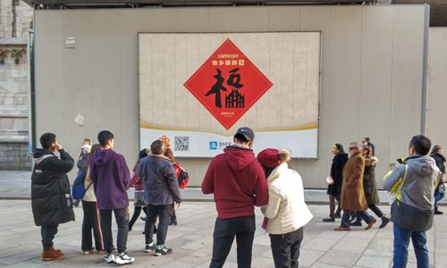 Los turistas chinos se reunieron alrededor de un cartel de la campa?a de Alipay en las afueras de la Catedral de Milán durante las vacaciones del A?o Nuevo Lunar de 2019.