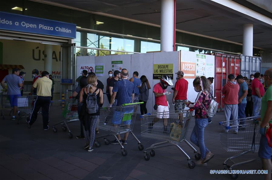 CHILLAN, 29 marzo, 2020 (Xinhua) -- Personas portando mascarillas hacen fila para entrar a un supermercado, en la ciudad de Chillán, en la región de ?uble, Chile, el 29 de marzo de 2020. El gobierno de Chile informó el domingo que existen 2.139 casos confirmados de la enfermedad causada por el nuevo coronavirus (COVID-19) y siete víctimas mortales de la enfermedad en el país. (Xinhua/Str)