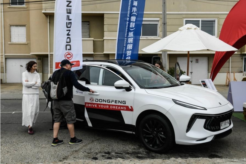 Personas observan un automóvil durante la primera Exposición Itinerante Internacional de Automóviles Chinos en Chile, organizada por el Consejo Chino para el Fomento del Comercio Internacional (CCPIT), en Vi?a del Mar, Chile, el 5 de marzo de 2024. (Xinhua/Jorge Villegas)